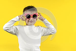 baby boy in sunglasses on yellow background