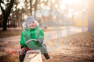 baby boy swinging in autumn park