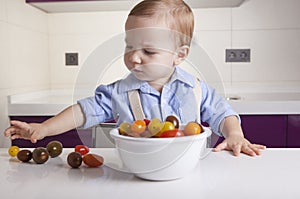 Baby boy taking ripe colorful cherry tomatoes