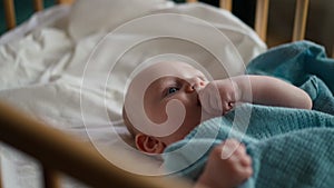 Baby boy toddler crawling in crib at kids nursery room at home.