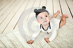 Baby boy in toddler and mouse hat on wooden floor