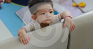 Baby boy toddler stand in fluffy mattress partition