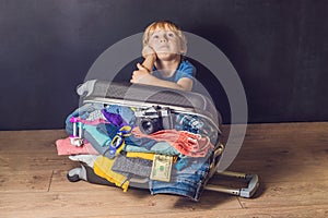 Baby boy and Travel Suitcase. Kid and Luggage Packed for Vacation Full of Clothes, Child and Family Trip