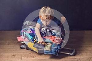 Baby boy and Travel Suitcase. Kid and Luggage Packed for Vacation Full of Clothes, Child and Family Trip