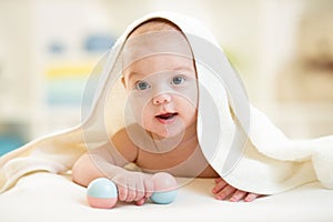 Baby boy under the towel after bathing at home