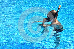 Baby boy in the water mask in the pool. Child swimmer in the water autdoor.