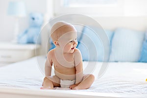 Baby boy on white bed