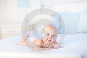 Baby boy on white bed