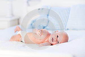 Baby boy on white bed