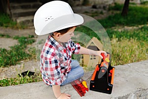 Baby boy in white construction helmet