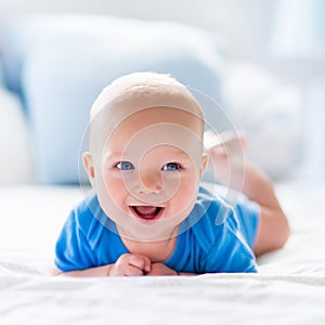 Baby boy in white sunny bedroom