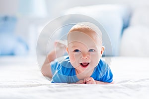 Baby boy in white sunny bedroom