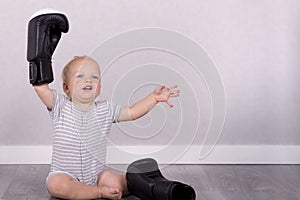 Baby boy winner. Cute toddler in a boxing gloves. Copy space. Studio shot