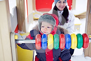 Baby boy on a winter playground