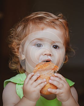 Baby with bread. Cute toddler child eating sandwich, self feeding concept.