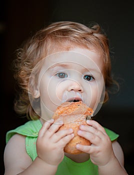 Baby with bread. Cute toddler child eating sandwich, self feeding concept.