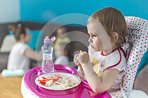 Baby breakfasts tomatoes with bread