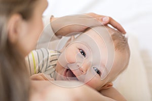 Baby breastfeeding. Mother holding her newborn child. Little kid laughing and looking at camera.