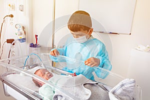 Baby brother and premature born infant child crib