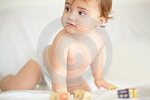 Baby, building blocks and playing on bed, education and learning for child development in bedroom. Sensory, alphabet and
