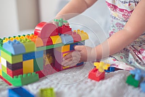 Baby builds house from designer, close-up, real
