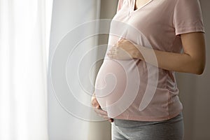 Baby bump of pregnant woman wearing pink t-shirt