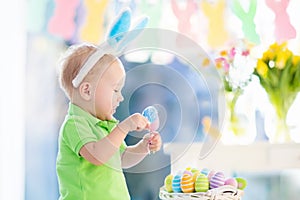 Baby with bunny ears on Easter egg hunt