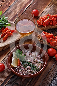 Baby calamari in olive oil with bruschettas and wine photo