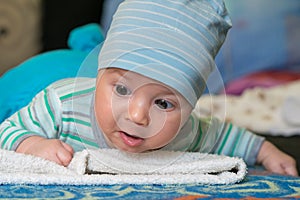 Baby with a cap enjoying on mothers shoulder