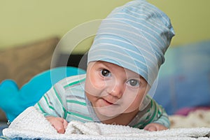 Baby with a cap enjoying on mothers shoulder