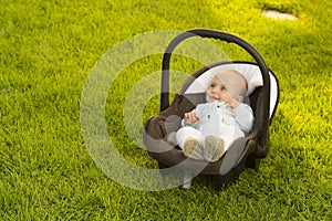 Baby in car seat on grass