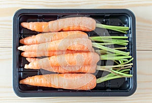 Baby carrots in a black container vintage filter applied