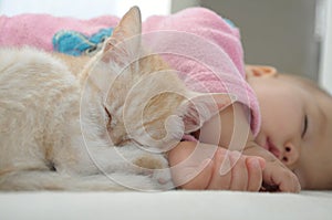 Baby and cat daytime sleeping together