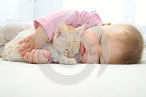 Baby and cat sleeping together