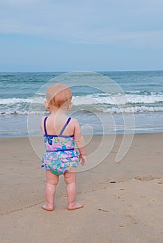 Baby Child on Beach Stares at Ocean