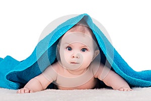 Baby child with big eyes under blue towel