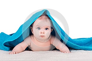 Baby child with big eyes under blue towel