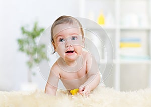 Baby child crawling on fluffy carpet and smiling