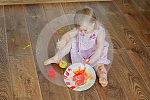 Baby child draws with colored paints hands, dirty feet and fingers. Child artistic experiences. Little artist