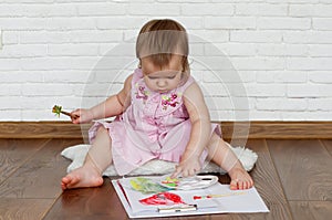 Baby child draws with colored paints hands, dirty feet and fingers. Child artistic experiences. Little artist