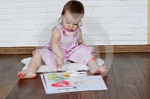 Baby child draws with colored paints hands, dirty feet and fingers. Child artistic experiences. Little artist