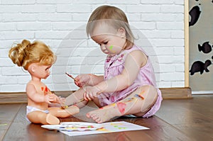 Baby child draws with colored paints hands, dirty feet and fingers. Child artistic experiences. Little artist