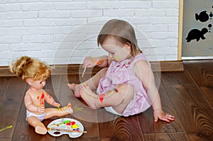 Baby child draws with colored paints hands, dirty feet and fingers. Child artistic experiences. Little artist