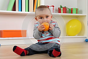 Baby child eating orange fruit