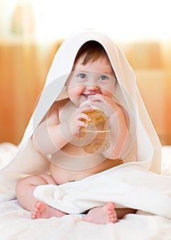 Baby child girl drinks water from bottle wrapped