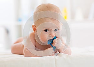 Baby child lying on belly weared diaper with teether