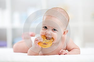 Baby child lying on belly weared diaper with teether