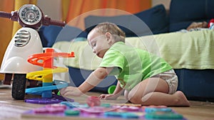 baby child plays with a toy slide and rolls a ball. happy family kid dream concept. baby play indoors with toys develops