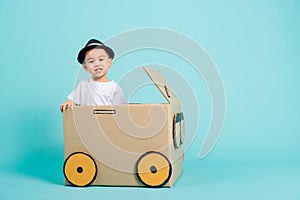 Baby children boy smile in driving play car creative by a cardboard box