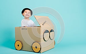 Baby children boy smile in driving play car creative by a cardboard box